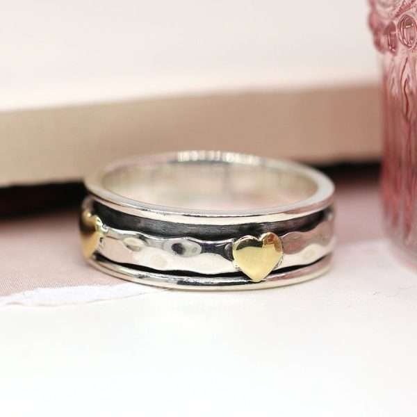Sterling silver spinning ring with hammered moving band and multiple brass hearts