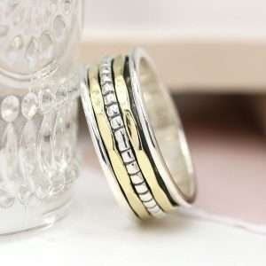 Sterling silver spinning ring with simple double brass and silver dotted silver bands