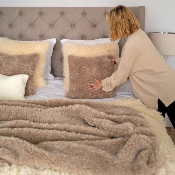 A large 2m curly faux fur throw in natural pebble shade.