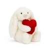 A white bunny soft toy cuddling a red velvet heart from Jellycat