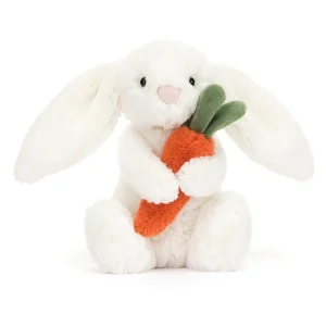 A soft toy from Jellycat a white fluffy bunny with a cute face holding a daffodil