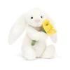 A soft toy from Jellycat a white fluffy bunny with a cute face holding a daffodil