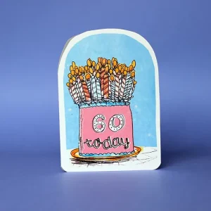A birthday card with a pink cake on a blue background. there are 60 candles on the cake and 60 today on the front of the cake