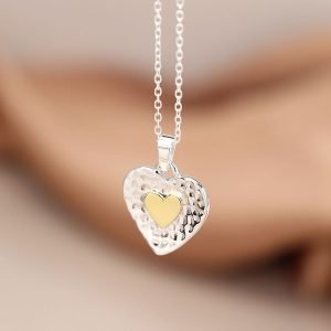 Sterling silver fine chain necklace with a hammered heart shaped pendant, featuring a brass heart inlay