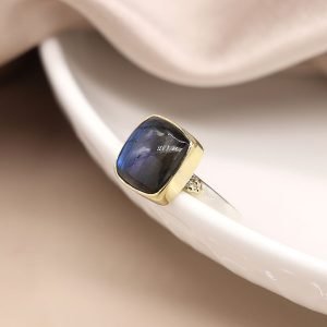 Sterling silver ring with a fine band and a large quare labradorite cabochon, in a brass plated setting