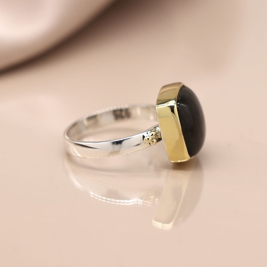 Sterling silver ring with a fine band and a large quare labradorite cabochon, in a brass plated setting
