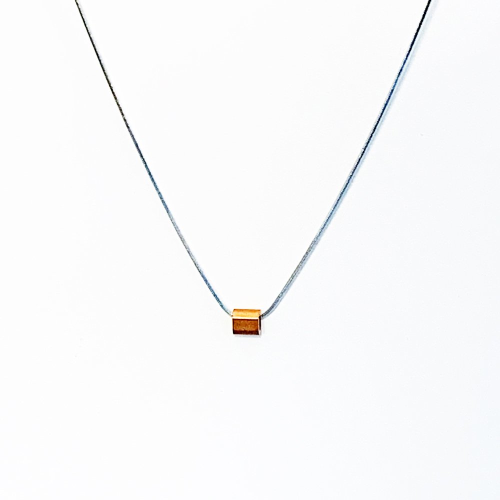 A stainless steel snake chain necklace with a copper tube pendant