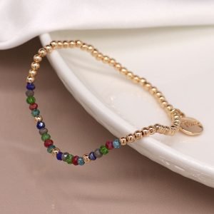 Faux gold plated fine bead bracelet with a row of multicoloured faceted beads and a POM flower tag