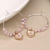 Silver plated wire hoop earrings with pale pink beads, tiny golden spacer beads and embossed shell inset hearts charms with crystal centres